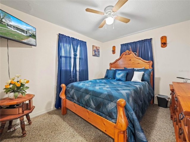 bedroom with a ceiling fan, a textured ceiling, and baseboards