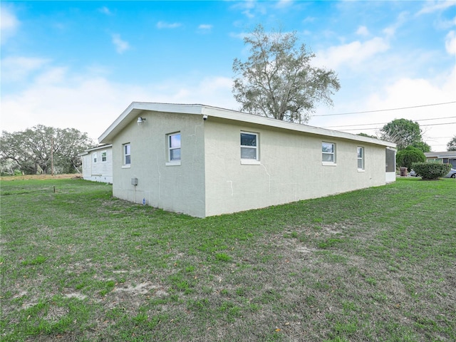 view of side of property featuring a yard and stucco siding