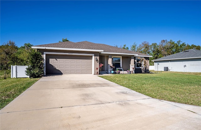 ranch-style home featuring stucco siding, concrete driveway, a front yard, fence, and a garage