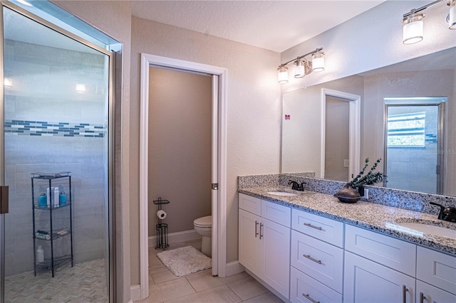 full bath with double vanity, tile patterned flooring, a sink, and toilet