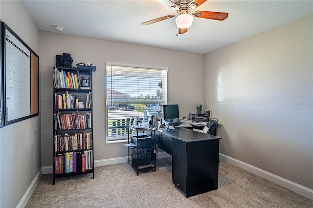 office area featuring light carpet, ceiling fan, a textured ceiling, and baseboards