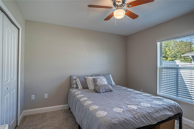 bedroom with a ceiling fan, a closet, carpet flooring, and baseboards