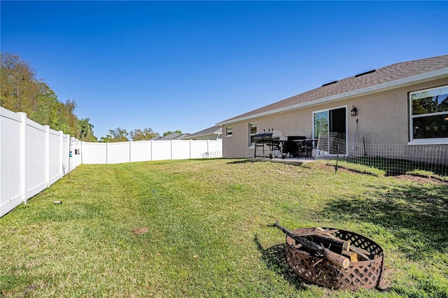 view of yard with an outdoor fire pit and a fenced backyard