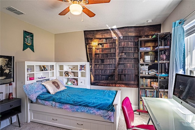 bedroom with carpet, visible vents, and a textured ceiling