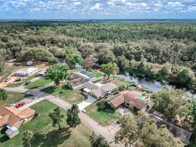 drone / aerial view with a water view and a wooded view