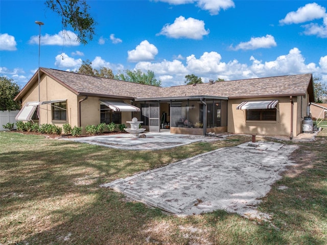 rear view of house featuring fence, a sunroom, a yard, stucco siding, and a patio area