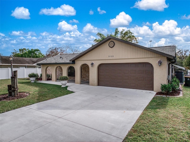 view of front of property with a garage, a front yard, fence, and driveway