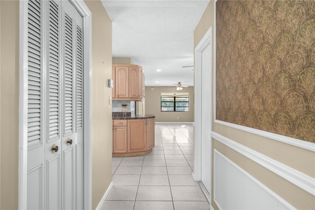 hall with light tile patterned floors, baseboards, a textured ceiling, and recessed lighting