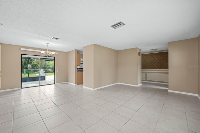 unfurnished room with light tile patterned floors, a textured ceiling, visible vents, baseboards, and an inviting chandelier