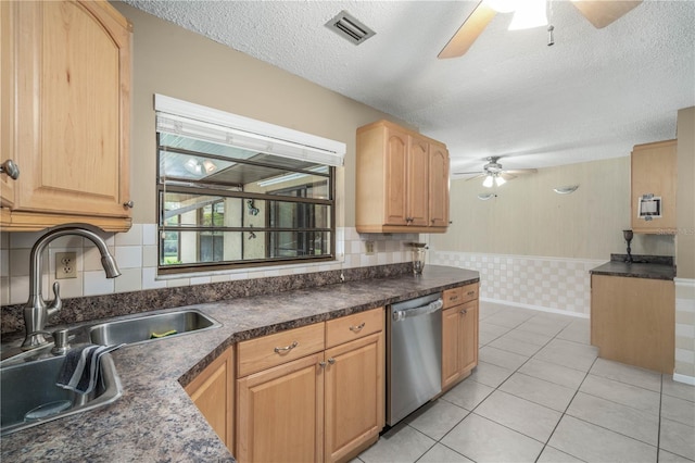 kitchen with ceiling fan, a sink, visible vents, stainless steel dishwasher, and dark countertops