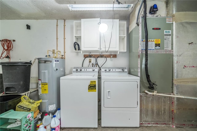 clothes washing area featuring water heater, laundry area, and washer and clothes dryer