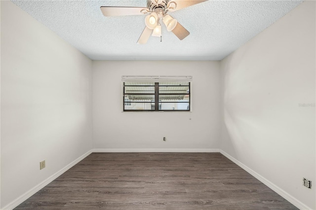 empty room with a textured ceiling, wood finished floors, and baseboards