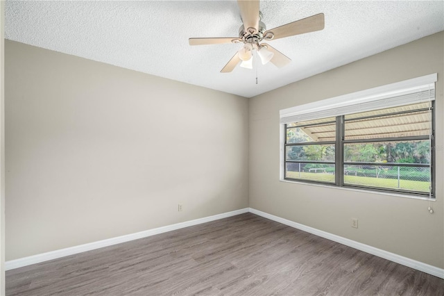 empty room featuring ceiling fan, a textured ceiling, baseboards, and wood finished floors