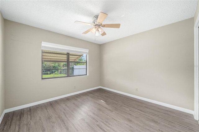 unfurnished room featuring a ceiling fan, a textured ceiling, baseboards, and wood finished floors