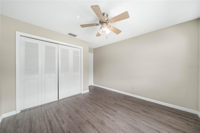 unfurnished bedroom with baseboards, visible vents, a closet, and wood finished floors