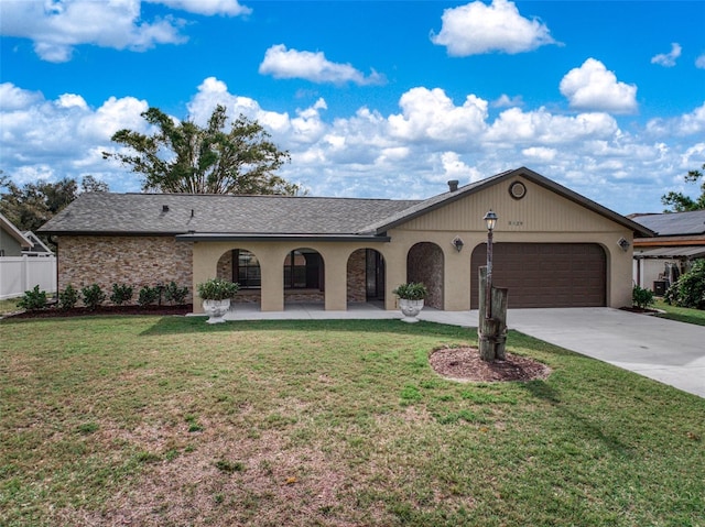 ranch-style home featuring a front lawn, concrete driveway, fence, and an attached garage