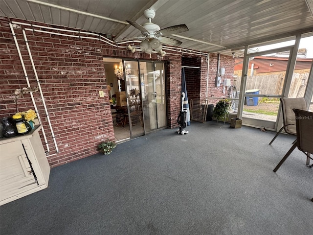 unfurnished sunroom with a ceiling fan and wood ceiling