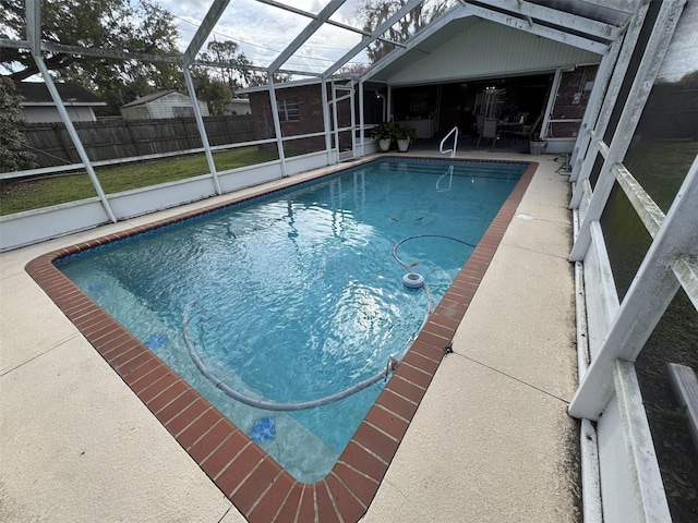 view of pool featuring glass enclosure, a patio area, fence, and a fenced in pool