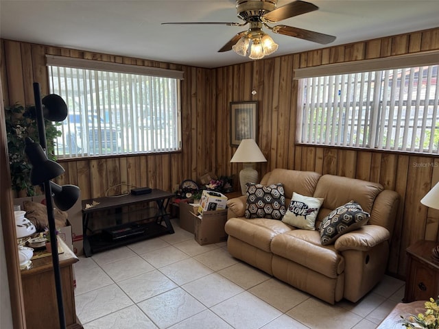 living area with light tile patterned floors, wood walls, and plenty of natural light