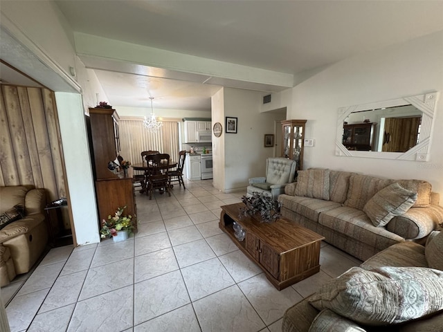 living area featuring an inviting chandelier, light tile patterned floors, and visible vents