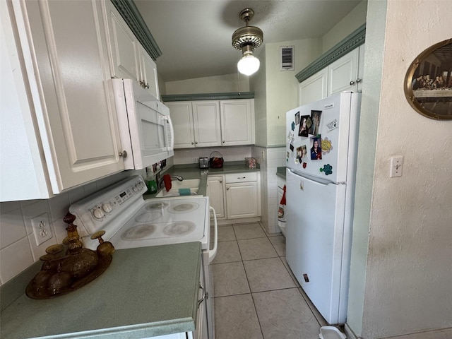 kitchen with white appliances, light tile patterned flooring, visible vents, and white cabinetry