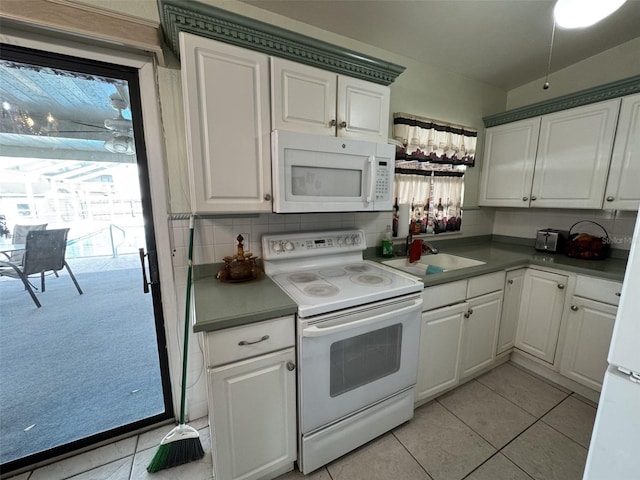 kitchen with white appliances, tasteful backsplash, white cabinetry, and a wealth of natural light