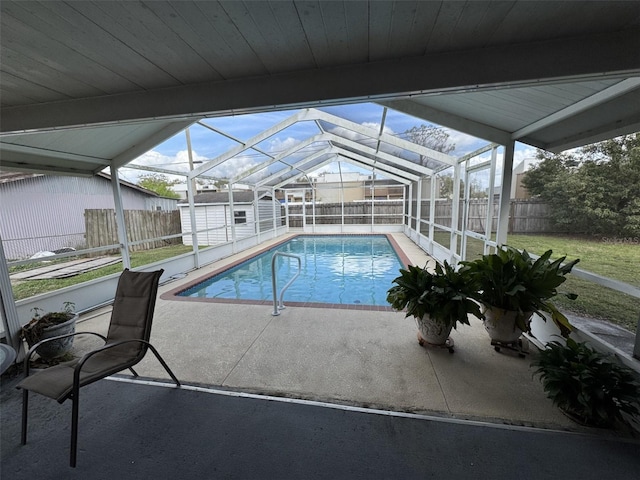 view of pool with glass enclosure, a fenced backyard, and a fenced in pool