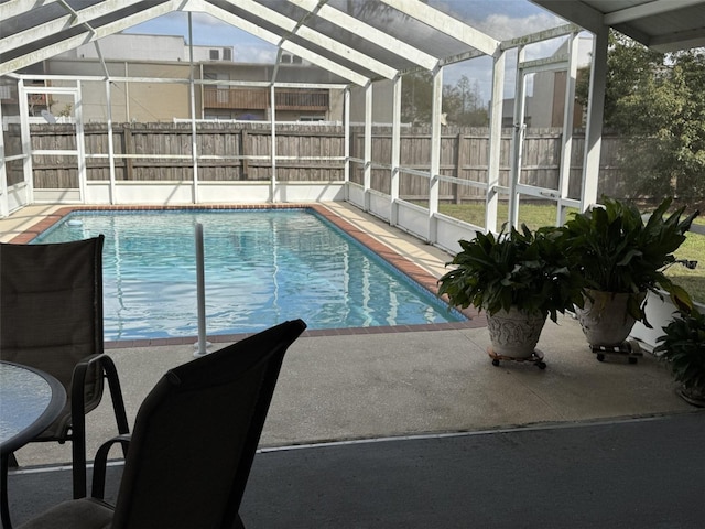 view of swimming pool featuring glass enclosure, a fenced backyard, and a fenced in pool