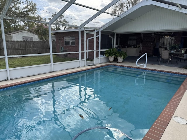 view of swimming pool featuring glass enclosure, a patio area, fence, and a fenced in pool