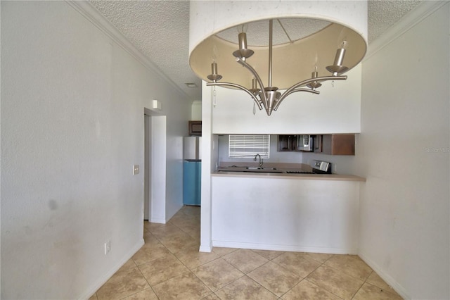 kitchen with a textured ceiling, light tile patterned floors, stainless steel appliances, a sink, and crown molding