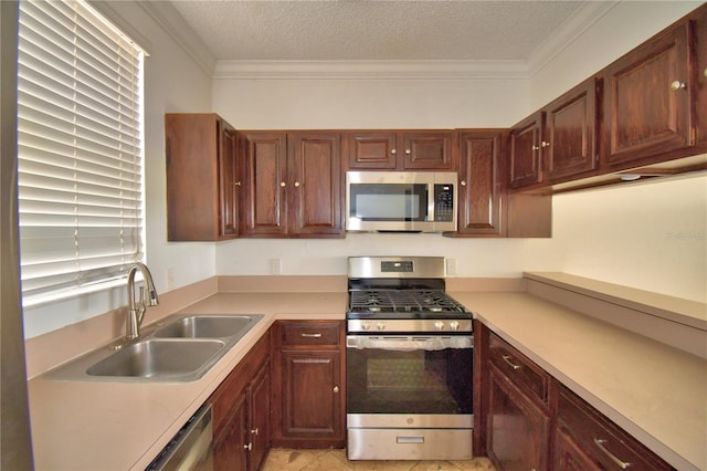 kitchen with crown molding, light countertops, appliances with stainless steel finishes, a sink, and a textured ceiling