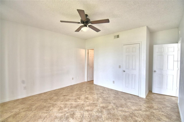 unfurnished bedroom featuring ceiling fan, a closet, a textured ceiling, and visible vents