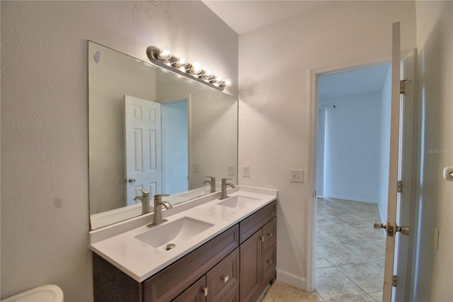 bathroom featuring tile patterned floors, a sink, and double vanity