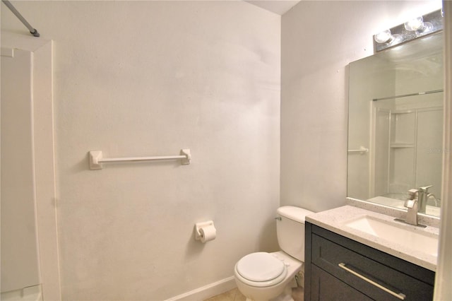 bathroom featuring walk in shower, vanity, toilet, and baseboards