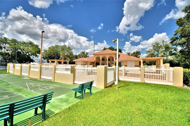 view of community featuring a yard, fence, and shuffleboard