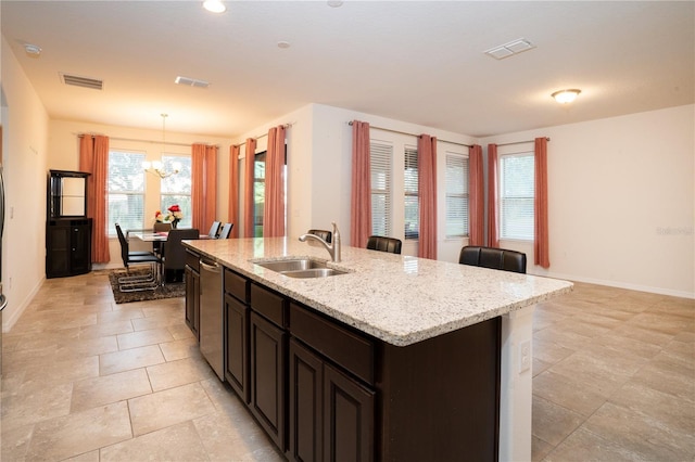 kitchen with visible vents, a chandelier, a center island with sink, dishwasher, and a sink