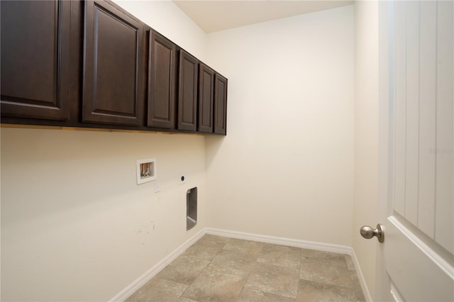 washroom featuring baseboards, washer hookup, cabinet space, stone finish floor, and electric dryer hookup
