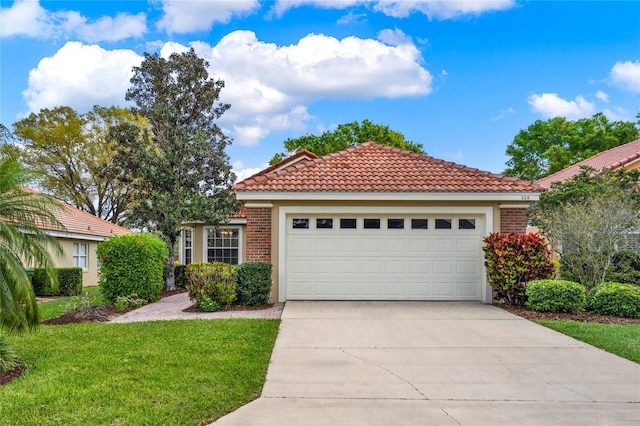 view of front of home with a garage, a front yard, brick siding, and driveway