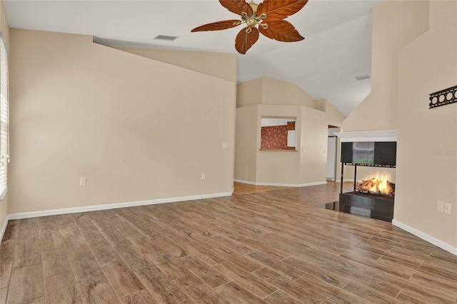 unfurnished living room with visible vents, a multi sided fireplace, ceiling fan, wood finished floors, and baseboards