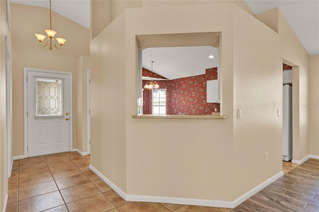 entrance foyer with lofted ceiling, light tile patterned floors, baseboards, and a chandelier