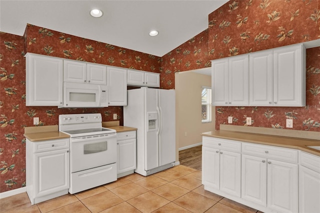 kitchen featuring white appliances, light tile patterned floors, baseboards, and wallpapered walls