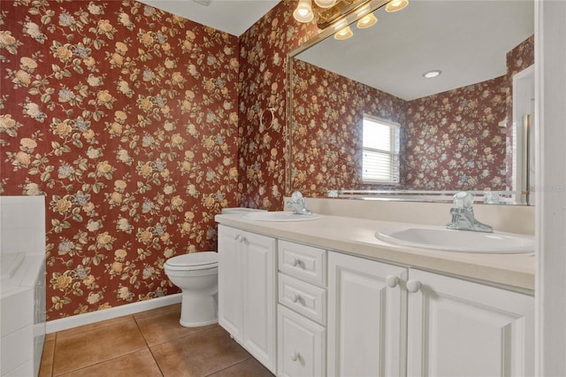 bathroom featuring baseboards, tile patterned floors, a sink, and wallpapered walls