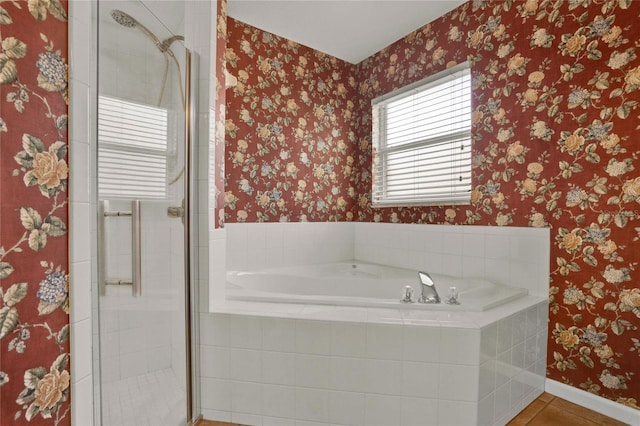 full bathroom with a stall shower, a bath, and wallpapered walls