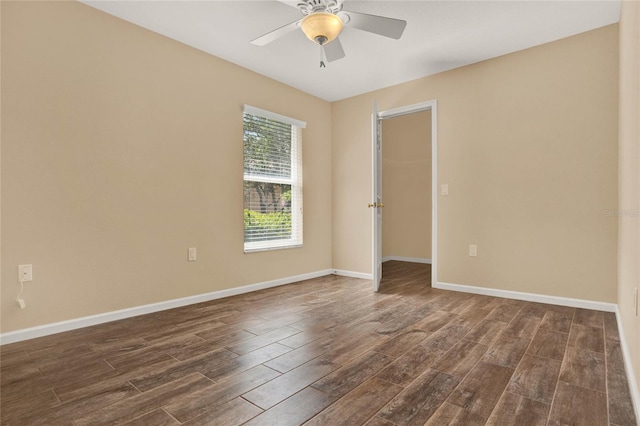 unfurnished room featuring dark wood-style floors, ceiling fan, and baseboards