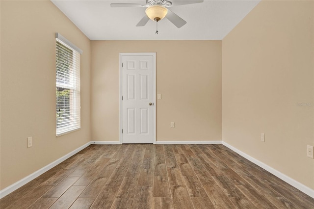 empty room with a ceiling fan, baseboards, and wood finished floors