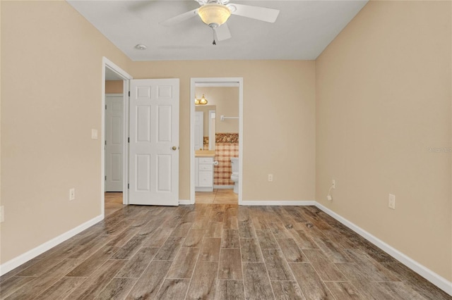 unfurnished room with wood finished floors, a ceiling fan, and baseboards