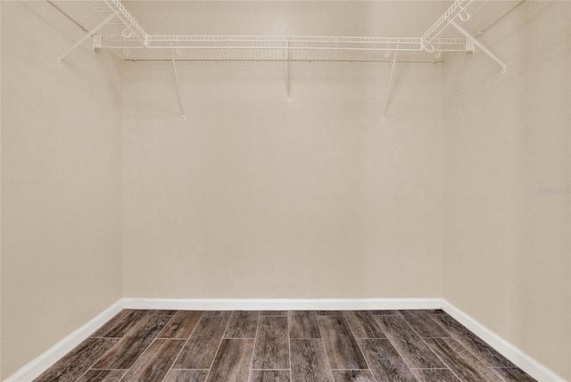 walk in closet with wood finish floors