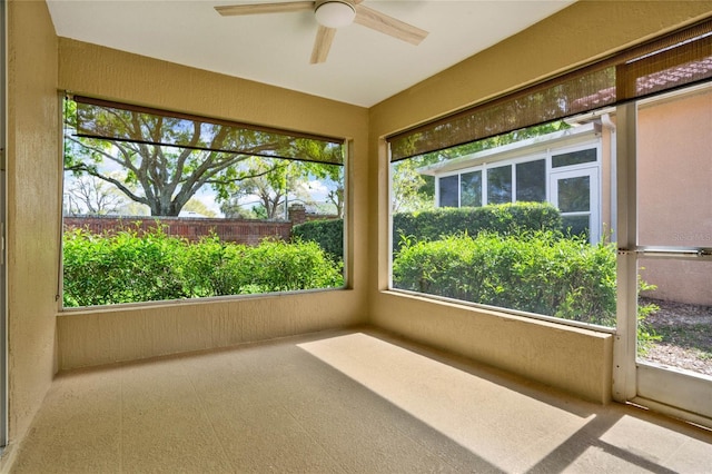 unfurnished sunroom featuring ceiling fan