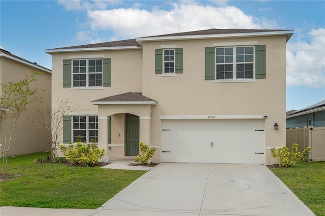 view of front of home featuring stucco siding, concrete driveway, an attached garage, a front yard, and fence