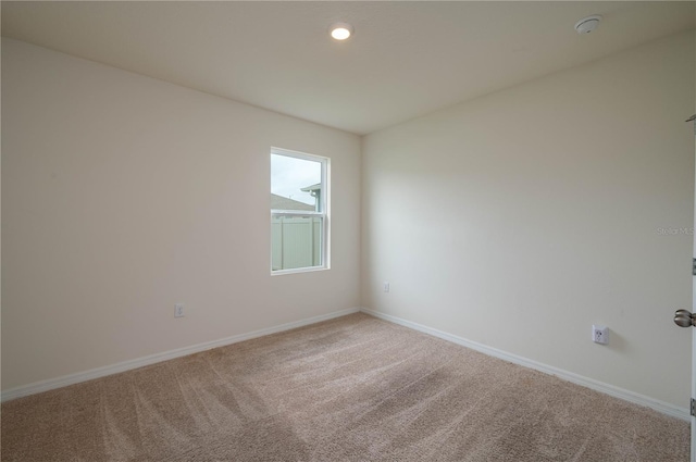 spare room with recessed lighting, carpet, and baseboards